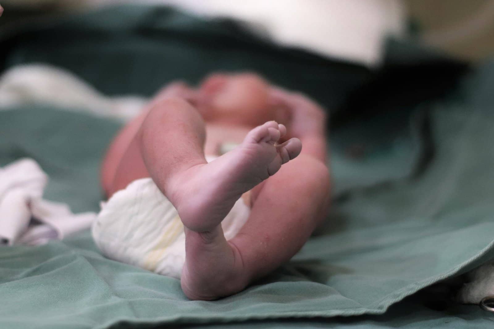 Close-up of a newborn's feet on a hospital bed, capturing the essence of new life.