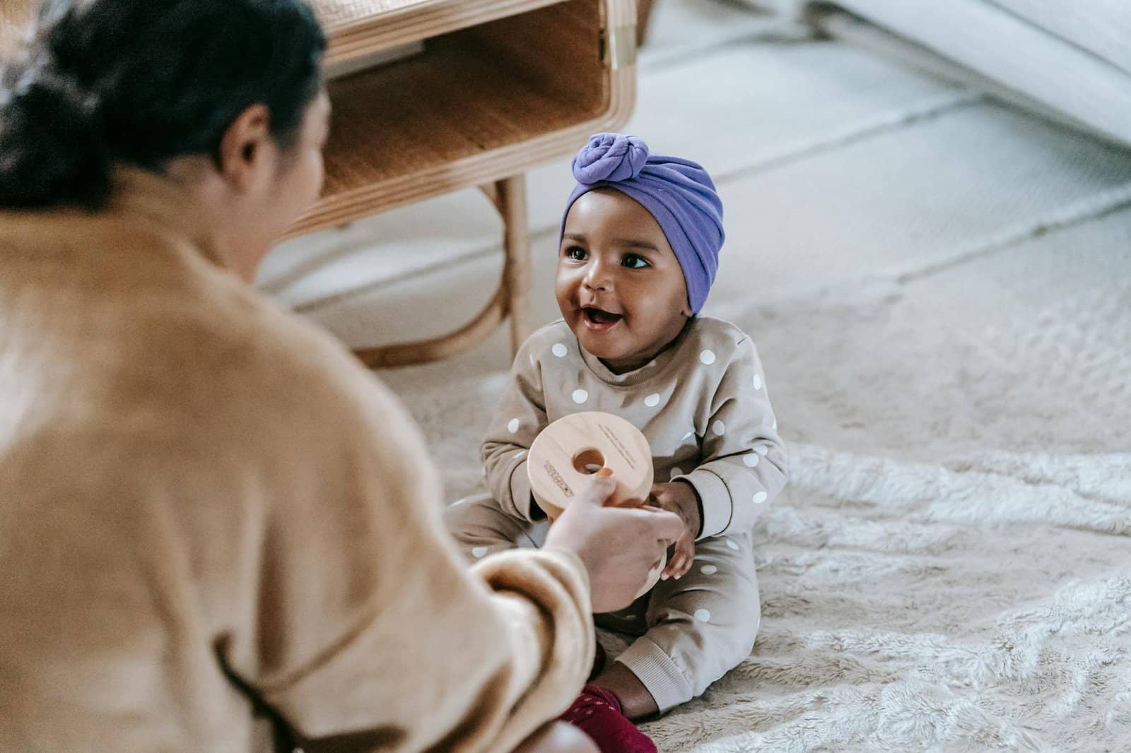a mother giving toy to her baby